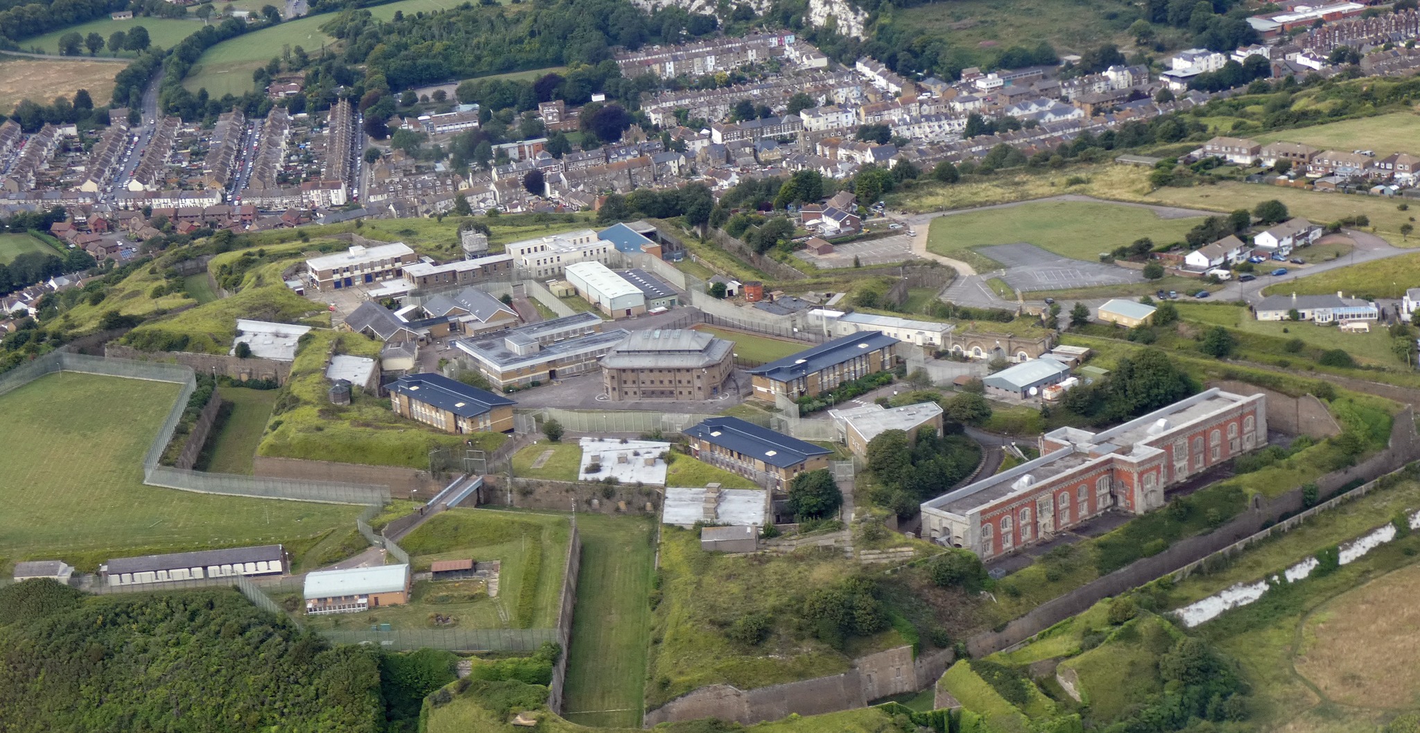 Aerial view of mixed use buildings on a hilltop with housing in the distance