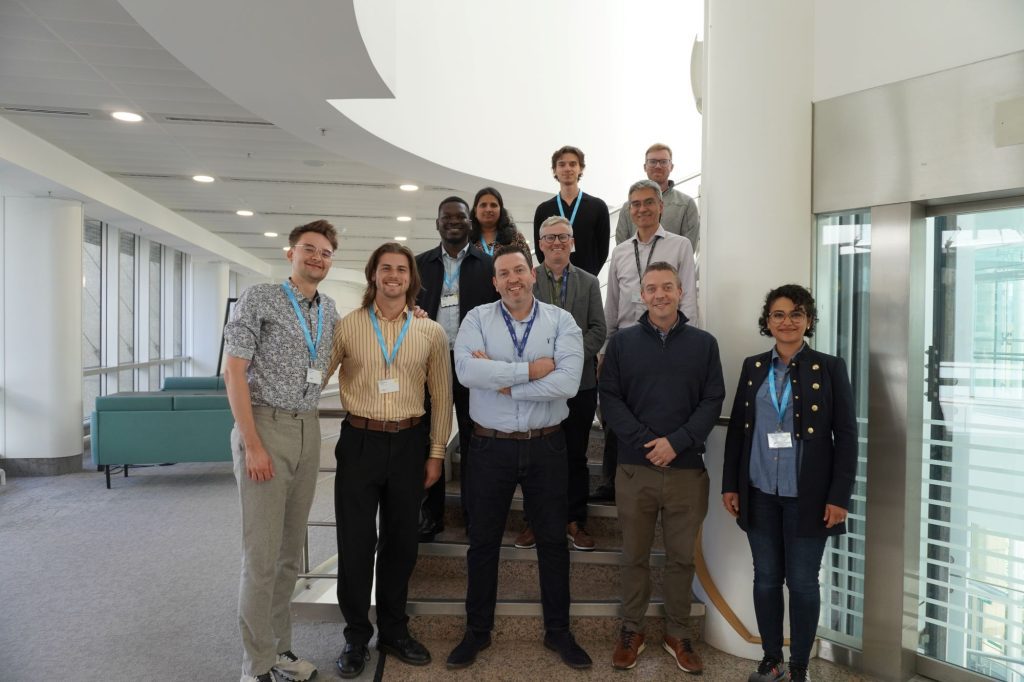 Eleven people standing on stairs smiling at the camera.